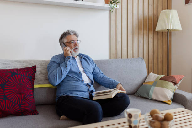 istock Happy man talking on the phone at home 1472480963
