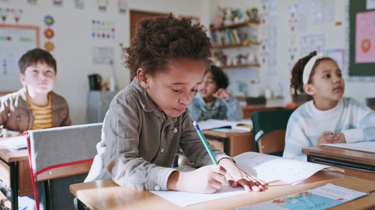 Learning, education and student drawing in classroom, studying or writing on paper. Examination, art development and creative black boy or kid with knowledge or creativity in kindergarten or school.