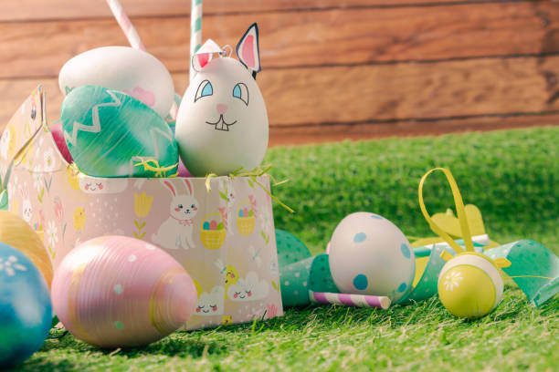istock Easter Basket with Colorful Eggs and Ribbons on Green Grass 1472482265