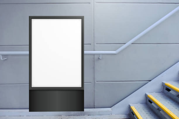 пустой белый вертикальный цифровой дисплей перед окрашенной бетонной стеной, рядом с лестничным пролетом. шаблон для макета рекламного пл� - poster window display store window стоковые фото и изображения