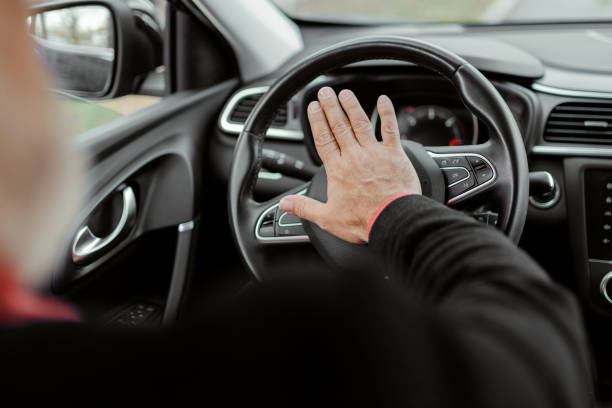 Pressing the Horn Man pressing the horn while driving a car through the road vehicle interior audio stock pictures, royalty-free photos & images