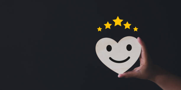 Heart shaped wooden sign in child's hand, happy, smiling, relaxed face. Good response rating Positive thinking Customer reviews Assessment Satisfaction World Mental Health Day Calm Good mood Good mood signo de madera en forma de corazón en la mano del niño, cara feliz, sonriente y relajada. buena calificación de respuesta pensamiento positivo opiniones de clientes evaluación satisfacción día mundial de la salud mental calma buen humor buen humor