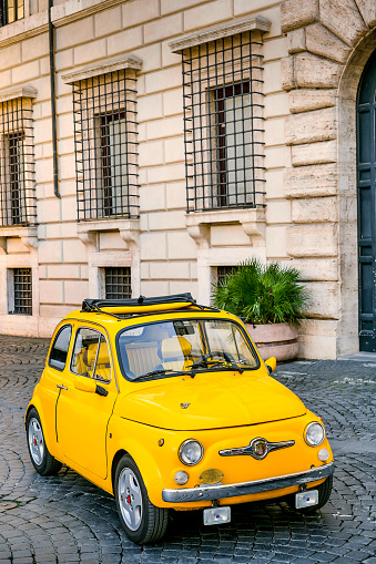 Rome, Italy, March 04 -- A lovely vintage Fiat 500 from 1972 parked in a corner of Piazza Navona, in the historic and Baroque heart of Rome. Piazza Navona is one of the most iconic squares of the Eternal City and one of the most famous in the world, located in the Parione district, one of the most visited districts of Rome for the presence of countless artistic and historical treasures, monuments and ancient Renaissance and Baroque churches, but also for its squares and alleys to be explored freely, where it is easy to find typical restaurants, small artisan shops, street artists, and discover the original Roman soul. In 1980 the historic center of Rome was declared a World Heritage Site by Unesco. Image in high definition quality.