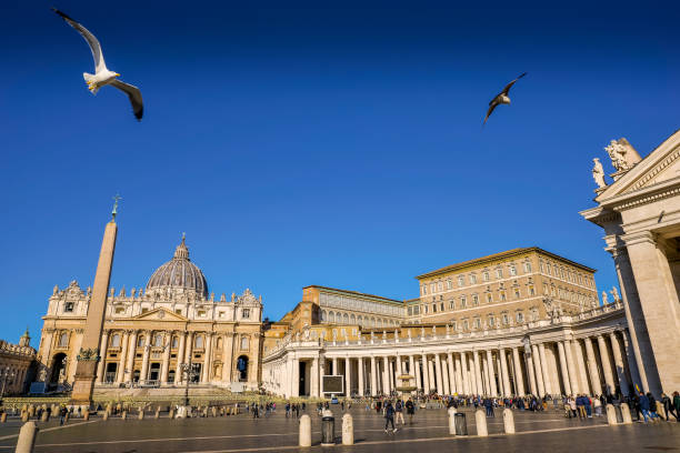 Some seagulls fly over the square of St. Peter's Basilica in the historic and spiritual heart of Rome stock photo