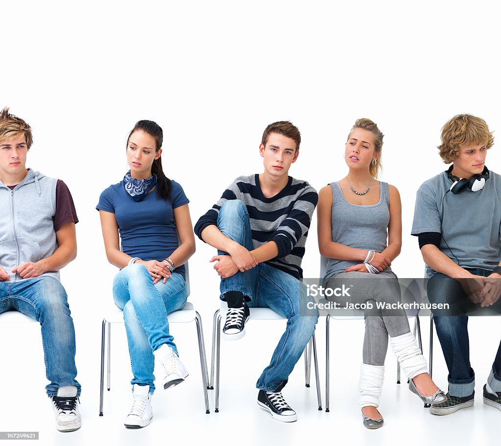 Men and women sitting on chairs in a line Front View Stock Photo