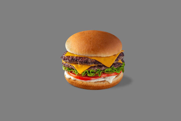 istock Double Cheeseburger with beef patty, lettuce, fresh tomatoes, pickles and mayonnaise sauce. Burger stands on a gray background. 1472497586