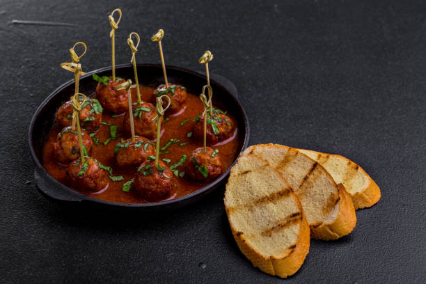 meatballs on a skewer with parsley in sauce on a stone plate and grilled hdeb on a stone dark background. horizontal orientation - salt beef fried angle imagens e fotografias de stock