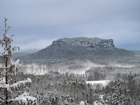 Verschneite Landschaft im Nationalpark Sächsische Schweiz mit dem Lilienstein im Zentrum des Bildes.