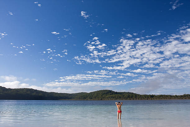 Young girl standing in the tranquil lake stock photo