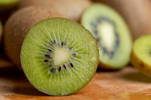 A group of cut green kiwi fruits with black seeds, details of green kiwi pulp cut into pieces