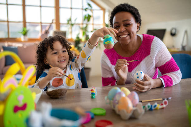 istock African mother and her multiracial son coloring Easter eggs at home 1472504814