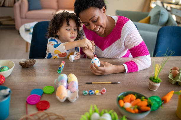istock African mother and her multiracial son coloring Easter eggs at home 1472504956