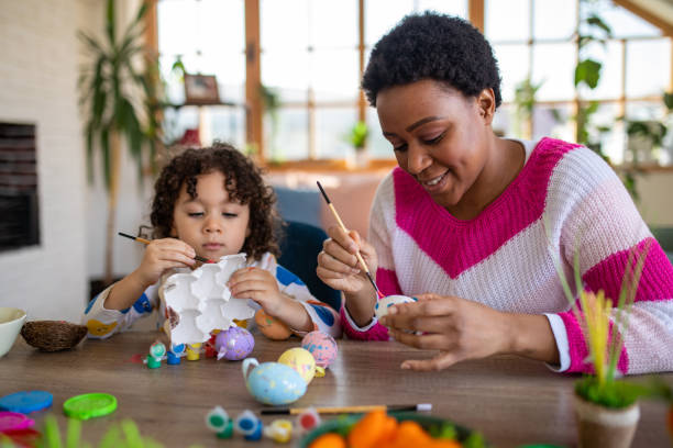 istock African mother and her multiracial son coloring Easter eggs at home 1472505058