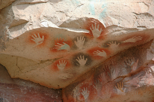 Ancient hands spray painted on rock wall in Patagonia.