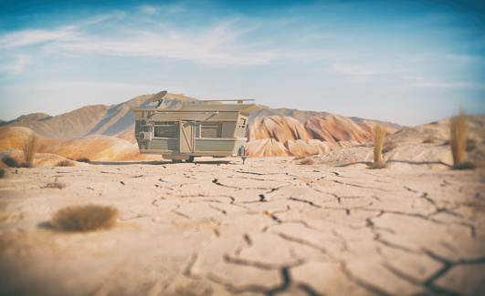 A beaten up old trailer sitting in a desert location. Scale model photography.