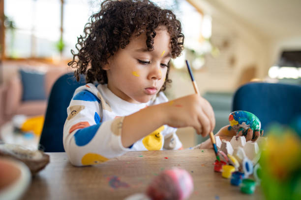 istock Multiracial boy painting an Easter egg at home 1472506376