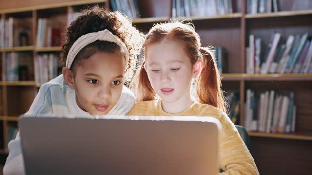 Talking kids, students or laptop in library for education research, learning games or growth development. Children, girls or friends technology in school bonding, studying support or website browsing