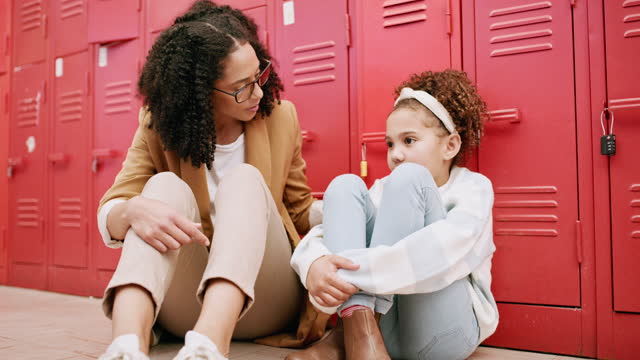 Teacher support, sad girl or child for school learning fear, bullying anxiety or scared with person empathy and help. Talking, mental health and black woman or education professional and kid on floor