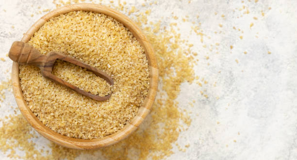 istock Raw Dry bulgur wheat grain on a plate top view copy space. Vegetarian and Middle Eastern cuisine 1472507881