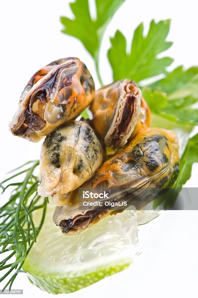 Seafood-mussels Seafood-mussels decoraded with greens and lime on ice Appetizer Stock Photo