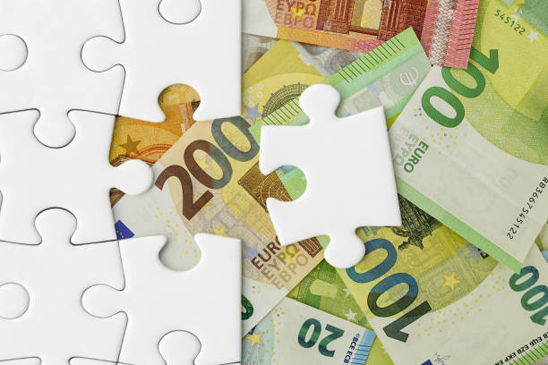 istock Insert the last puzzle piece into the puzzle against a European banknotes background 1472508802