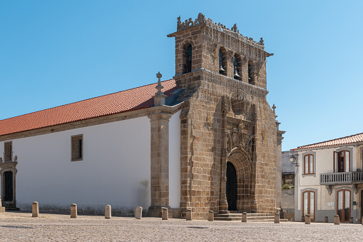 Facade of the sixteenth century Gothic Manueline church with a three bells belfry, Parish church in the main square of the town of Vila Nova de Foz Coa, Portugal