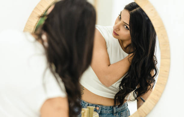 istock Woman Checking Her Hair in The Mirror 1472512521