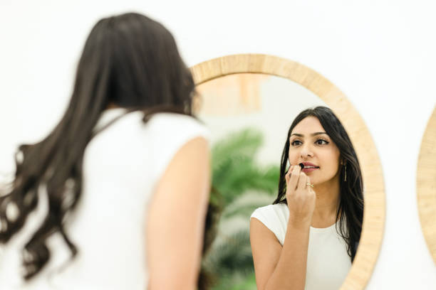 istock Woman Putting On Lipstick 1472512533