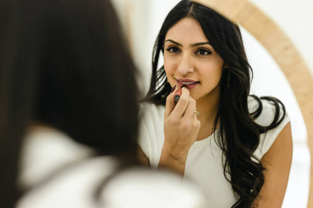 istock Woman Putting On Lipstick 1472512535
