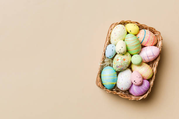 istock Colorful Easter eggs in wicker basket against colored background, closeup. top view with copy space 1472513807