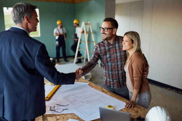 istock Happy couple came to an agreement with architect at construction site. 1472514234