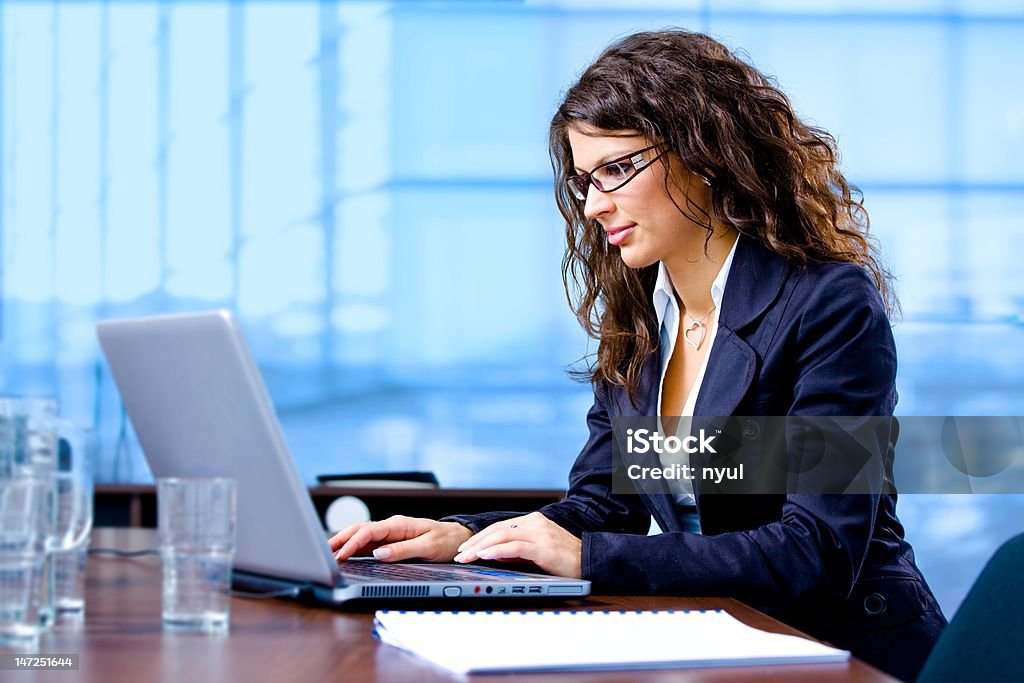 Femme d'affaires à l'aide d'un ordinateur portable - Photo de Cadre d'entreprise libre de droits