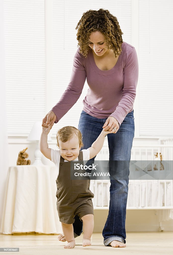 Mère aider son fils apprendre à pied - Photo de Cadrage en pied libre de droits