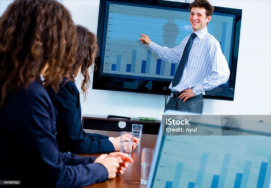 Man shows blue bar graph at a business seminar Businessman explaining progress on graph.  Click here for other business images:  Adult Stock Photo