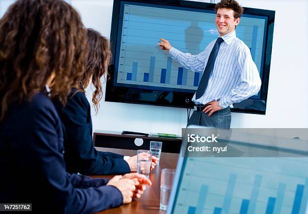 Man Shows Blue Bar Graph At A Business Seminar Stock Photo - Download Image Now - Adult, Adult Student, Adults Only