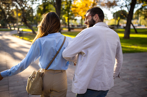Young couple walking together in a public park