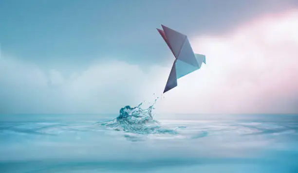 Peace concept. Conceptual photos to show the Freedom of White Origami Dove or Pigeon Flew from the Water into the Sky. International World Peace day, Human Rights, Love and Hope