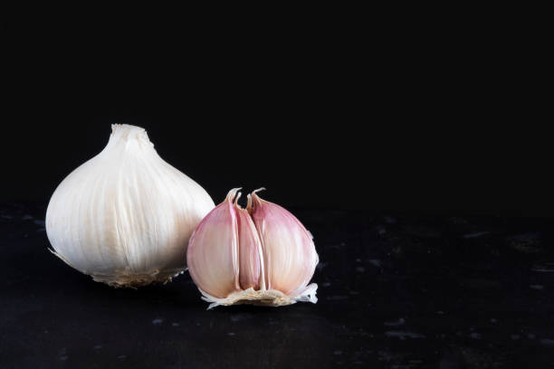 istock Garlic and garlic cloves isolated on a black background 1472521688