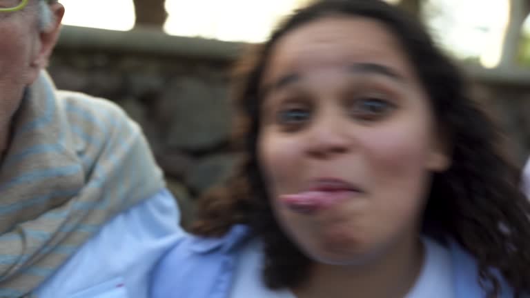 Multiracial people having fun together at city park doing funny facial expression - Concept of multi generational friends outdoor