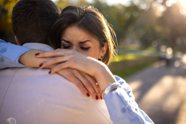 istock Young couple hugging in a public park 1472522600