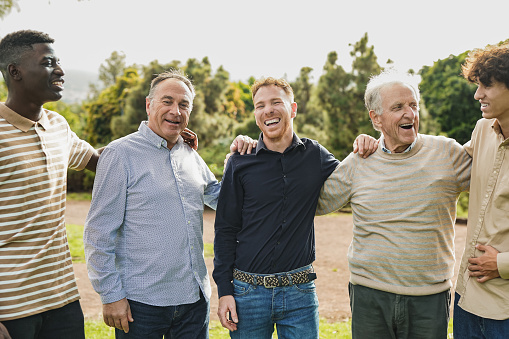 Multi generational men having fun together at city park - Multiracial male friends enjoy day outdoor