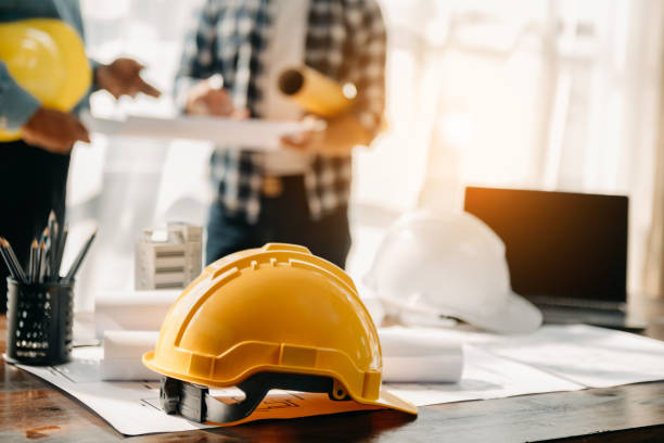 istock Engineer desk with object paper and tablet with blurry engineer teamwork hardworking to consults about their building project. 1472523359