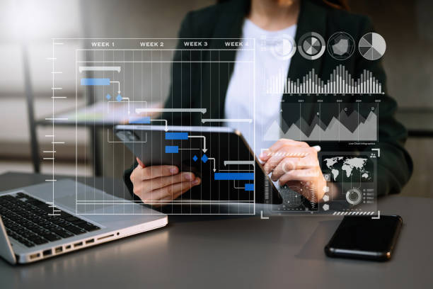istock Businessman hand Project manager working and update tasks and Gantt chart scheduling virtual diagram.with smart phone, tablet and laptop in office. 1472523385