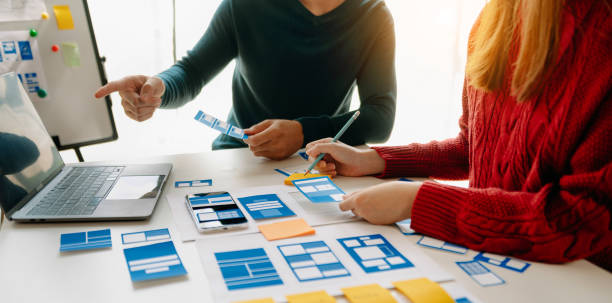 istock Close up view of UI developer team brainstorming on their project with laptop, smartphone and digital tablet. Creative digital development agency. 1472523414