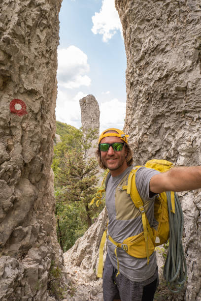 istock Mountain climber takes selfie with pinnacle rocks, ready to climb 1472525362