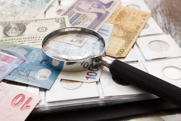 istock Different old collector's coins and magnifying glass 1472527210