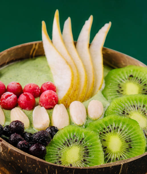 istock Green smoothie bowl with nuts, kiwi, pear, berry and granola 1472528270