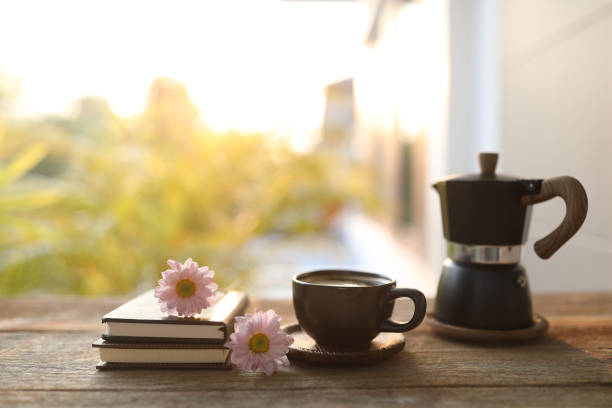istock Black coffee cup and moka pot and notebook diary and pink Chrysanthemum flowers 1472529059