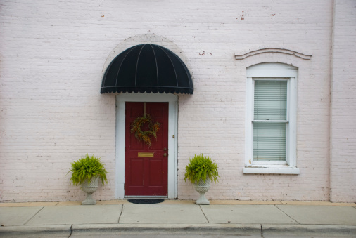 A light pink apartment's front door and window. Shot in downtown Washington, North Carolina.