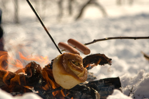Hot dogs and a cinnamon bun on the campfire in the Norwegian mountains during winter time. Tasty and relaxing after a day og Cross country skiing